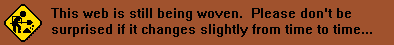 The words 'This web is still being woven. Please don't be suprised if it changes from time to time(dot dot dot)' on a red background. On the left there is a PNG of a black and yellow street sign depicting a simple figure shoveling dirt